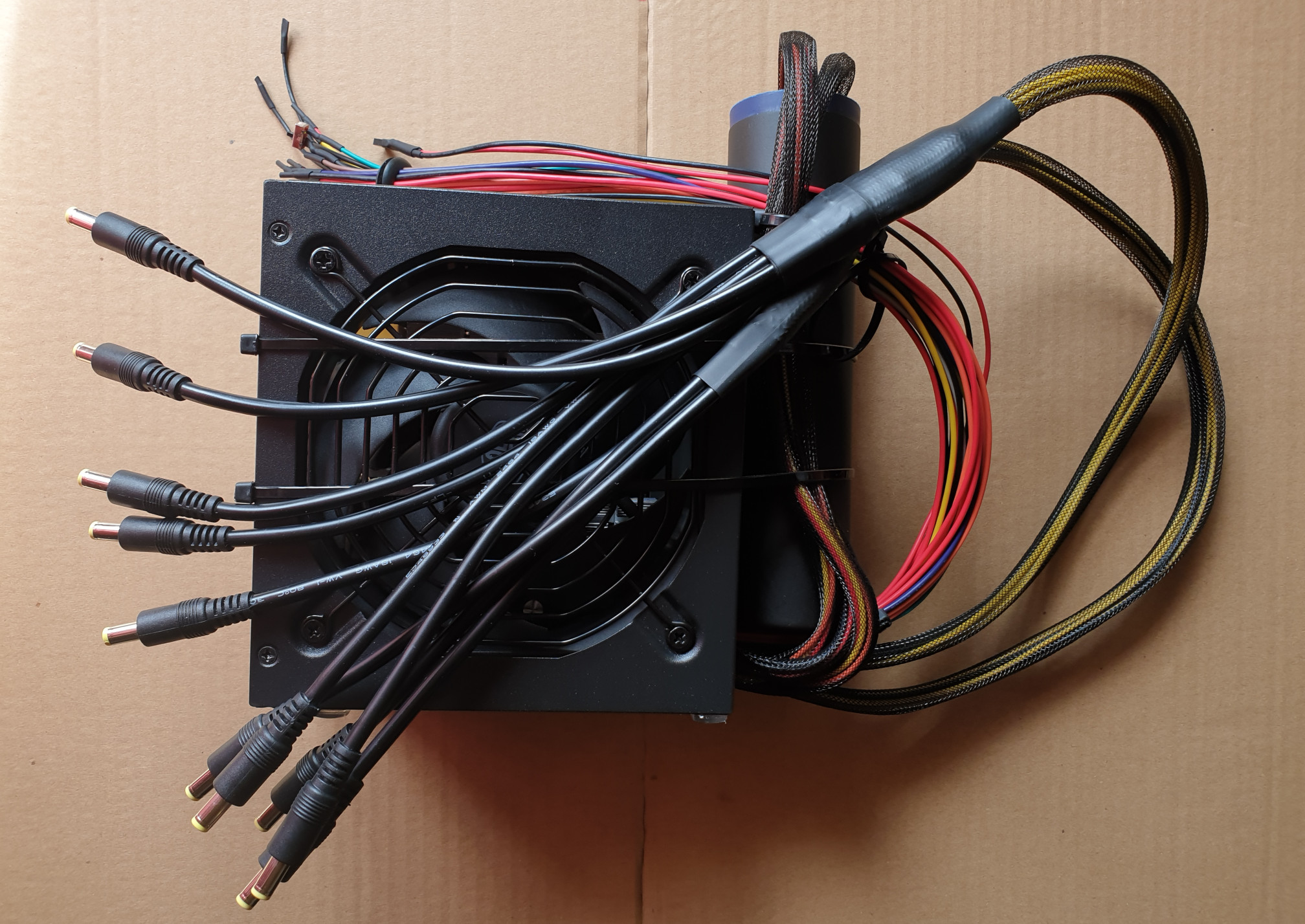ATX power supply with incomplete modifications, extra cables stored in the black cylinder 